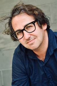 a man wearing glasses and a blue shirt